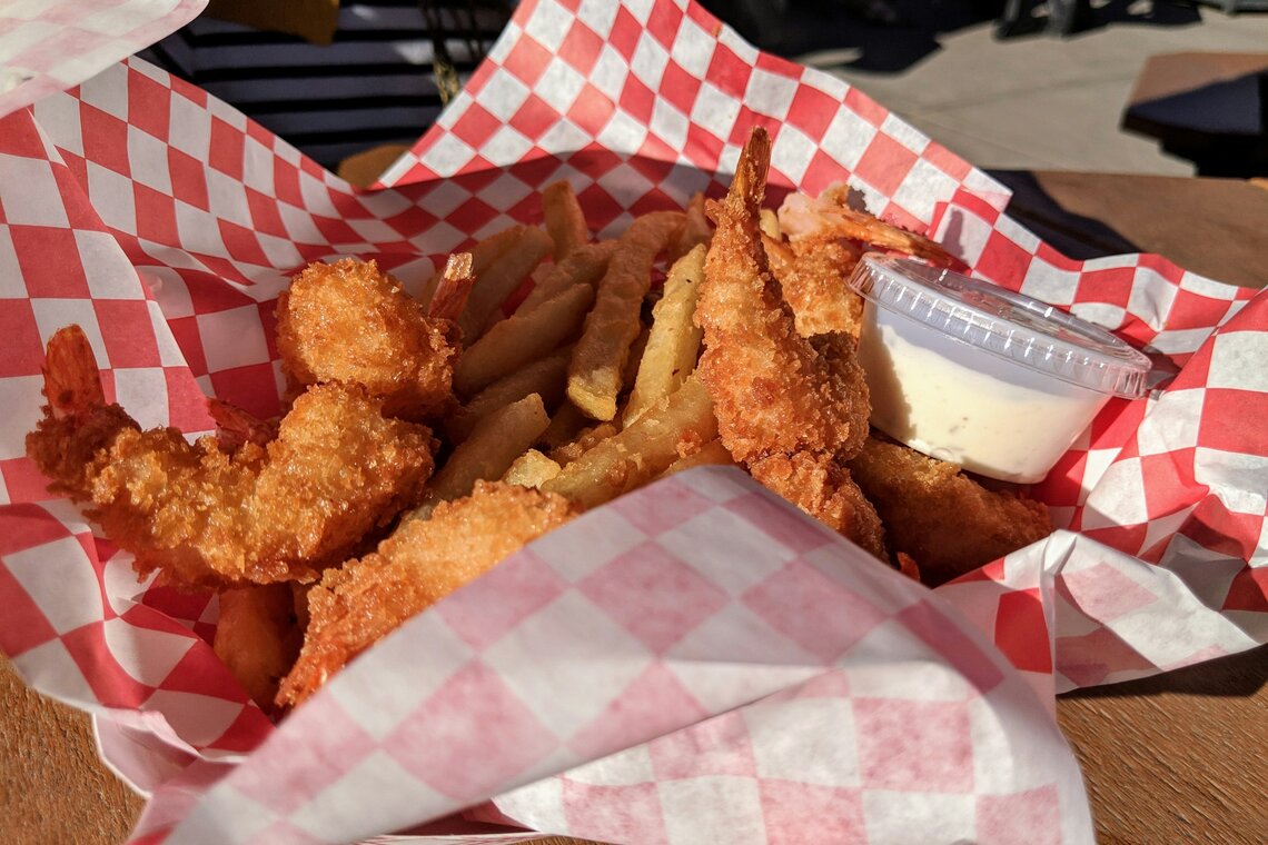 Fried shrimp with seasoned fries in a basket