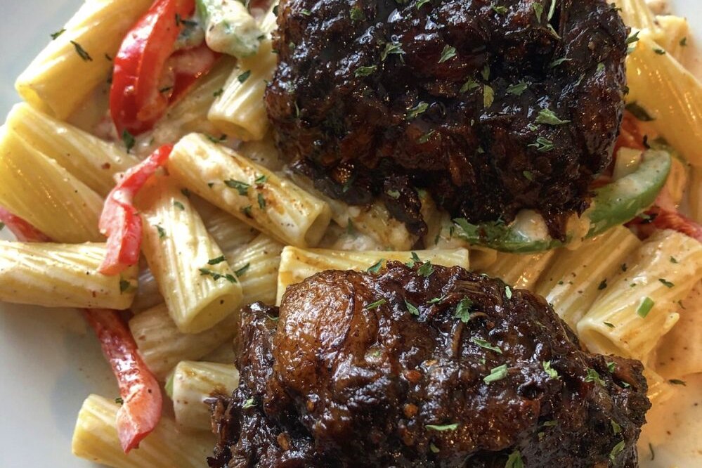Braised oxtail over rigatoni rasta pasta with peppers
