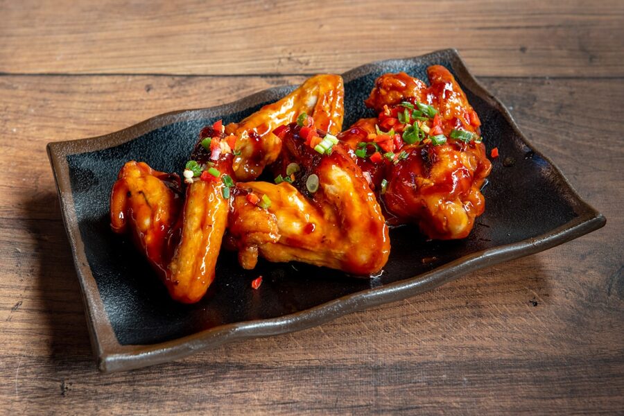 Sauced wings on a dark plate